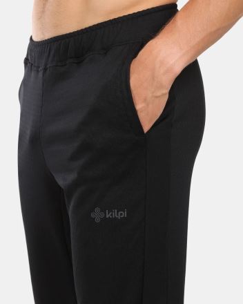 Detail Kilpi NATTY-M pánských sportovních kalhot černá L s rukou v kapse a viditelným logem na nohavici. (2)