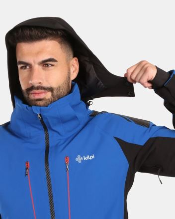 Model si upravuje kapuci Kilpi Lyžařská bunda TURNAU-M černá S, detailně ukazující střih a funkční prvky. (5)