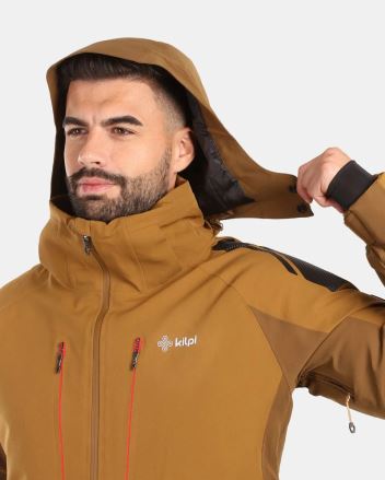 Detailní pohled na Kilpi Lyžařská bunda TURNAU-M černá S, muž si upravuje kapuci, viditelné logo a zipy. (4)