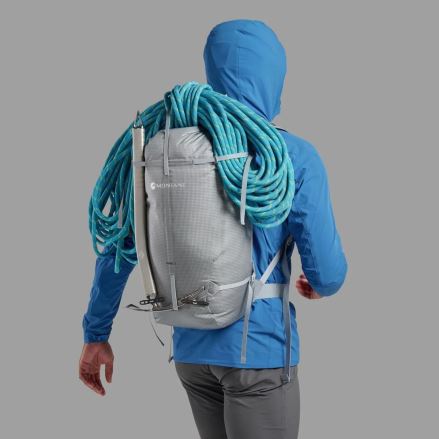 Pohled zezadu na osobu nesoucí šedý Batoh Montane Valen 30L neptune blue ONE SIZE s horolezeckým lanem a cepínem. (12)