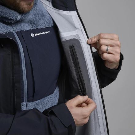 Detail Bundy Montane Torren Jacket black S, osoba zapíná hlavní zip a ukazuje vnitřní kapsu. (10)