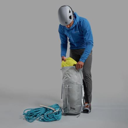 Osoba plní šedý Batoh Montane Valen 30L neptune blue ONE SIZE, vedle leží horolezecké lano a cepín. (14)
