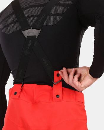 Detail odepínacích šlí Pánských lyžařských kalhot Kilpi METHONE-M černá 5XL na zádech s rukou ukazující uchycení. (7)