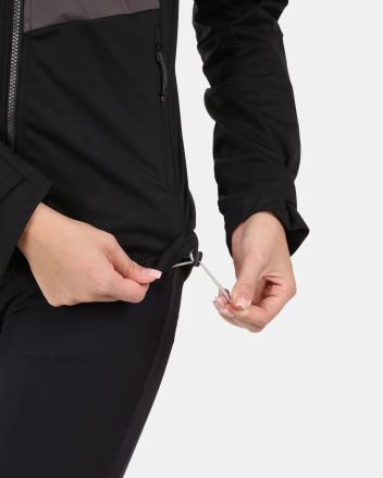 Žena stahuje spodní lem Dámské softshellové bundy Kilpi BELTRA-W černé. (6)
