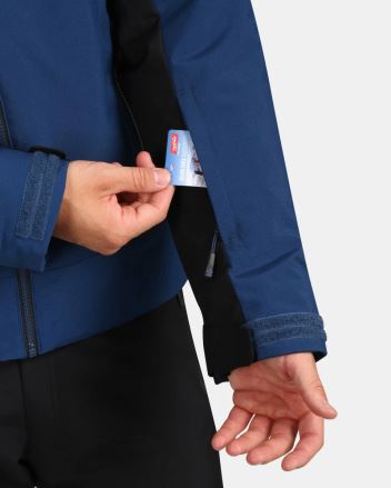 Detail ruky vkládající skipas do kapsy na rukávu Pánské lyžařské bundy Kilpi FLIP-M hnědá L. (3)