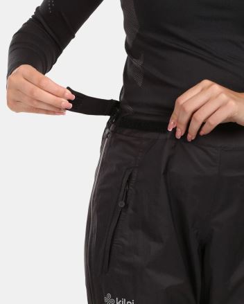 Detail dámských nepromokavých kalhot Kilpi ALPIN-W černá 34 s rukou nastavující suchý zip v pase. (3)