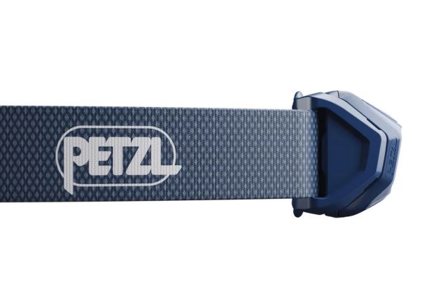 Detail čelovky Petzl Tikkina černá: boční pohled na modrý popruh s logem Petzl a tělo lampy. (2)